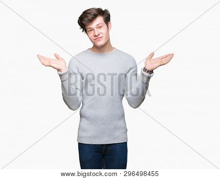 Young handsome man wearing winter sweater over isolated background Smiling showing both hands open palms, presenting and advertising comparison and balance