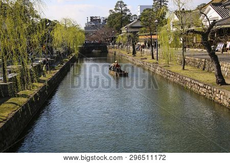 Kurashiki, Japan - March 31, 2019: Tourists Are Enjoying The Old-fashioned Boat Along The Kurashiki 