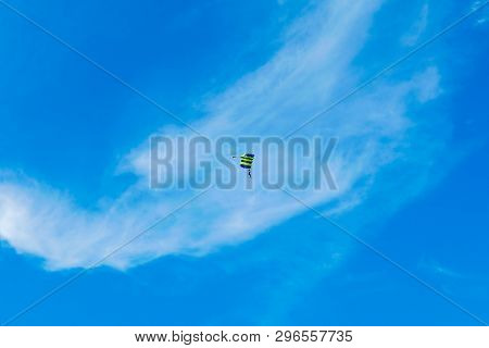 Male Skydiver Flies Under The Wing Of The Parachute, Descending And Coming In To Land Closer To The 