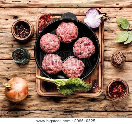 Raw Meatball Over Wooden Background