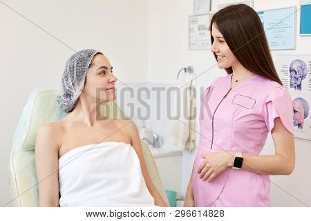 Indoor Shot Of Conversation, Rofessional Cosmetologist Examining Face Skin Of Her Beautiful Young Fe