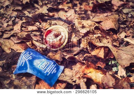 Sibiu, Romania - April 20, 2019. A Used Condom Speckled With Blood Near The Pack Threw In The Autumn