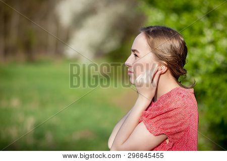 Close-up Of Female Hands Putting Hearing Aid In Ear. Modern Digital In The Ear Hearing Aid For Deafn
