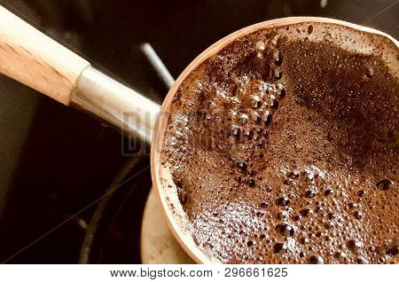 Barista Preparing Hot Tasty Drink From Copper Turk, Boils Water For Coffee On Small Fire In Cezve. C