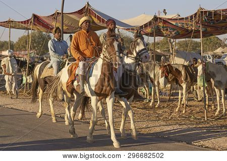 Nagaur, Rajasthan, India - February 13, 2008: Men Riding Horses Along A Track At The Annual Livestoc