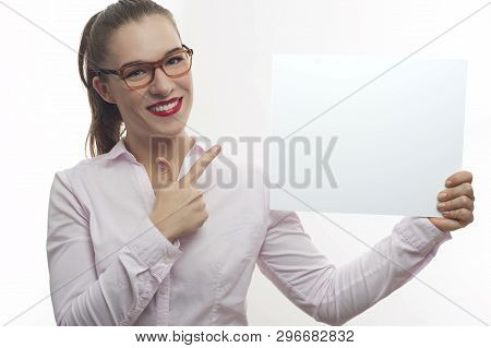 Young Woman In Pink Blouse Long Hair In Tail In Eyeglasses Happy Pointing With Finger At White Banne