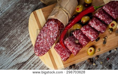 Italian Salami With Olives And Spices On Wooden Background