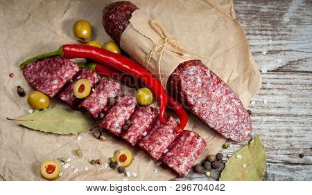 Italian Salami With Olives And Spices On Wooden Background