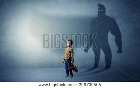 Cute kid in a room with plush on his hand and hero shadow on his background