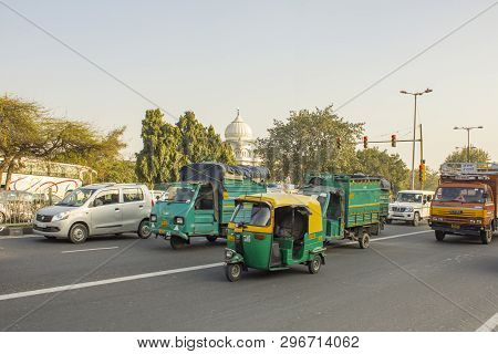 Delhi India - 09.02.2019 Indian Green Moto Trucks And Rickshaws In City Traffic On A Background Of G
