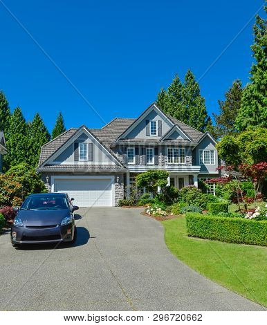 Luxury Residential House With Green Hedge And Landscaping In Front. Family House Surrounded By Trees