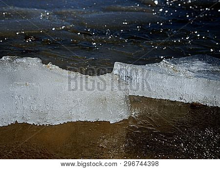 Frozen Bubbles In Drifting Floe. Arctic Ice Cough On Sandy Beach Slowly Melting Under Hot Sun. Clima