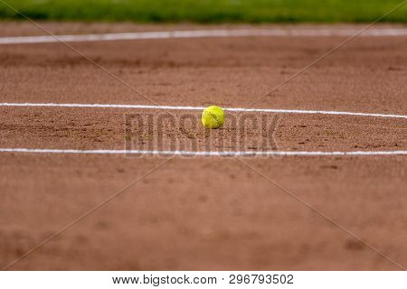 Fastpitch Softball Resting In Center Of Pitching Circle Between Innings Of A Game.
