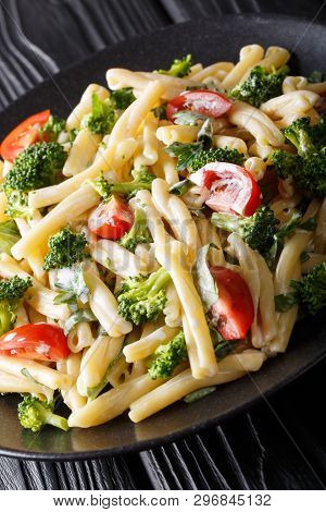 Casarecce Pasta With Broccoli, Garlic And Tomatoes In A Creamy Sauce Close-up. Vertical