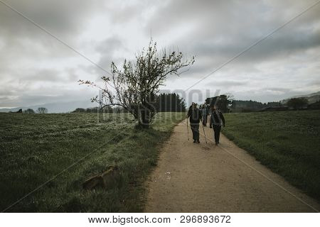 Sarria, Spain - April 6th, 2019: Group Of Pilgrims With Backpack Walking By Camino De Santiago Way I