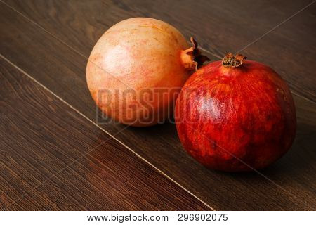 Stil Life - Red Whole And Cutted Pomegranate Fruits, Scattered Seeds And Glass With Juice On A Dark 