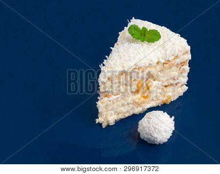A Piece Of White Cake With Almonds And Coconut Chips On Blue Onet. Decorated With Mint And Candy Wit