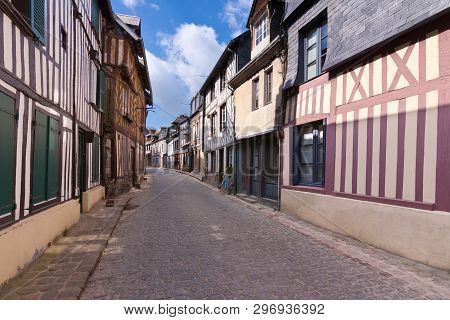 Curved Narrow Street With Old Wooden Buildings At Honfleur City, In Northern Normandy. Travel Destin