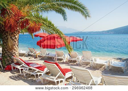 Summer Beach Vacation.  Sunny Mediterranean Landscape With Red Beach Umbrellas. Montenegro, Adriatic