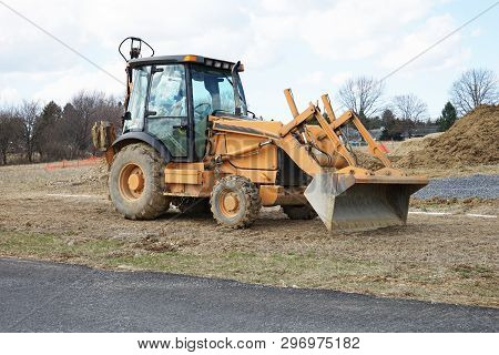 A Front End Loader Sits Idle Near A Construction Site.