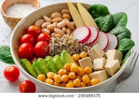 Healthy Vegan Buddha Bowl With Spinach, Tomato, Chickpea, Quinoa, Radish, Beans, Avocado, Mini Corn