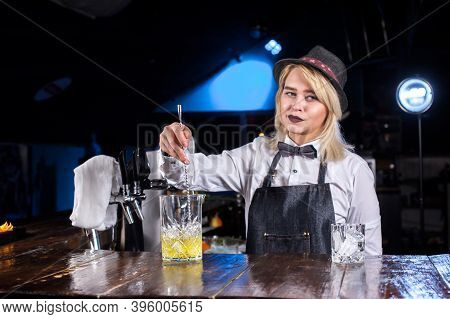 Expert Girl Bartender Decorates Colorful Concoction On The Bar