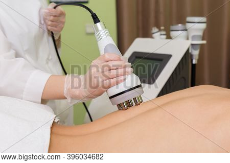 The Spa Beautician Holds The Rf-lifting Maniple In His Hand And Runs It Along The Clients Back.