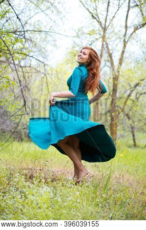 Beautiful Bootless Woman Dance In Forest. Barefoot Girl In Elegant Blue Dress Posing In Forest On Gr
