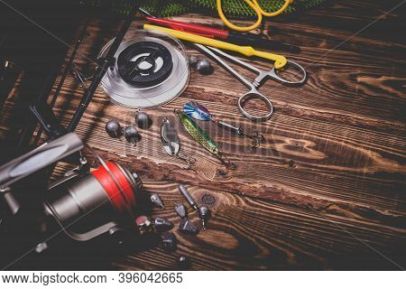 Fishing Tackle On A Wooden Background. Studio Photo With Vignetting.