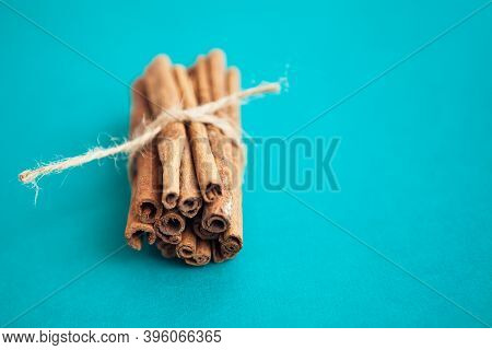 Cinnamon Sticks Held Together With Jute Rope On Turquois Background