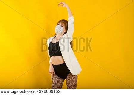 Female Strip Dancer In Yellow Studio In Protective Mask From Covid