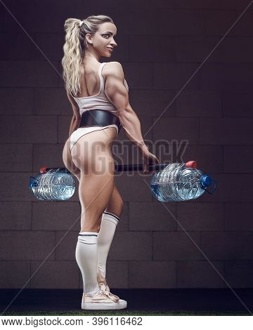 Fitness Woman Pumping Up Muscles At Home Workout With Water Bottel. Pretty Caucasian Fitness Girl An