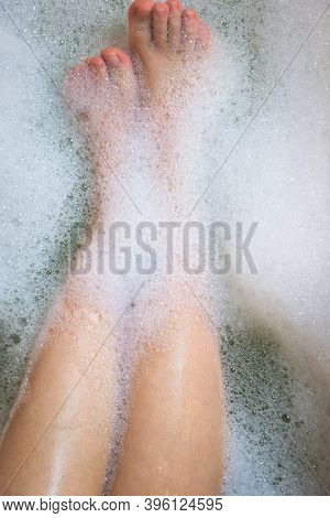 Women's Legs In The Bathtub, Bathing With Bubble Bath Foam Top View, Relaxtion Beauty Spa Concept
