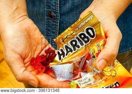 Tambov, Russian Federation - October 30, 2020 Woman Pouring Haribo Gummy Bears Candy  From Haribo Pa