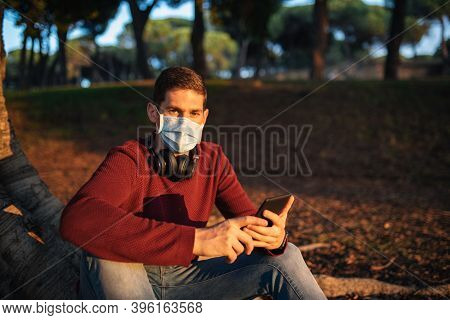 Boy With A Mask By The Covid-19, Reading An E-book, Sitting In A Tree At Sunset.