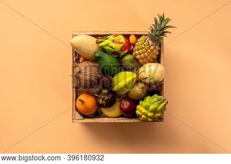 Fresh Exptic Fruits In Wooden Box Top View. Fruit Dragon, Papaya, Maracuya, Kiwi, Mango And Granadil