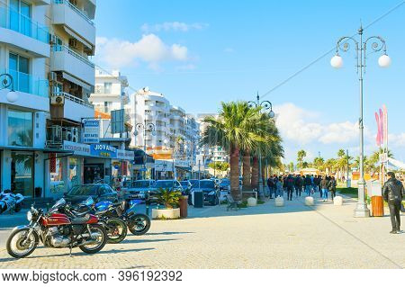 Larnaka, Cyprus - Feb 18, 2019: People Walking By Larnaca City Promenade With Typical Architecture B