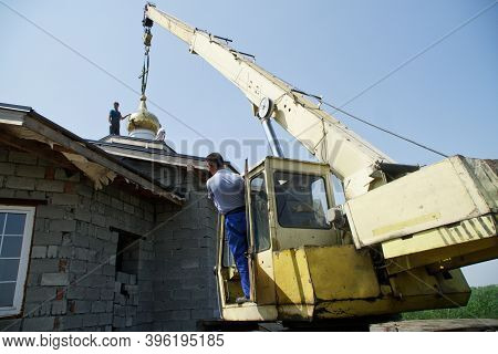 July 11, 2020, Russia, Magnitogorsk. A Crane Driver And An Industrial Climber Install A Dome With A 