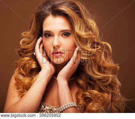 Beaity and fashion concept: Blond woman with long, healthy and shiny curly hair . Beautiful model woman with wavy hairstyle .Care and beauty.