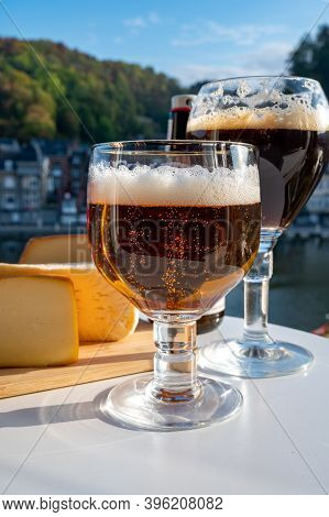Drinking Of Dark And Strong Belgian Abbey Beer With Cheeses With Nice View On Maas River And Town Di