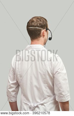 Male Doctor With Headphones. Studio Medicine Portrait. Clinic Online Help. Health Support Call. Tele
