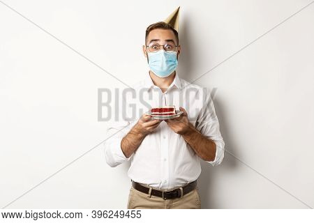 Covid-19, Social Distancing And Celebration. Surprised Birthday Guy Holding Bday Cake, Wearing Face 