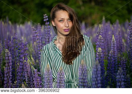 Gorgeous Beautiful Girl In Striped Summer Dress With Magnificent Dark Hair Posing On Blooming Meadow