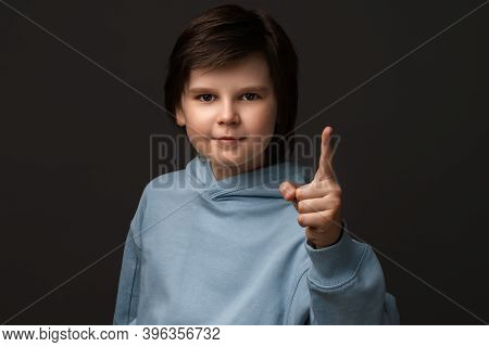 Portrait Of Serious Boy 10-12 Years Old In Casual Clothes Showing Index Finger, Scolding Or Telling 