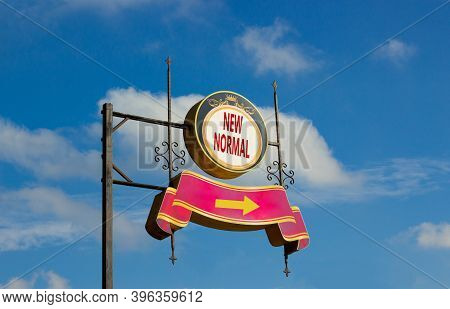 Time For A New Normal. Street Sign With Text 'new Normal' And Arrow On Metal Pole. Blue Sky Backgrou