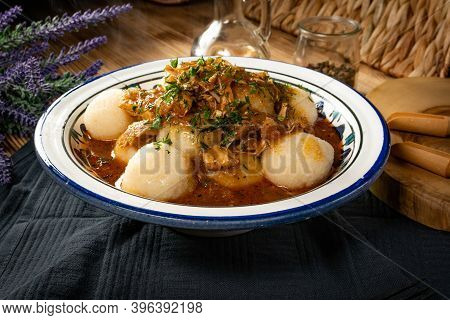 Dumplings With Turkey And Chorizo Sauce In A Painted Bowl.