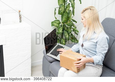 Transportation, Post And People Concept - Smiling Young Woman Opening Cardboard Box At Home