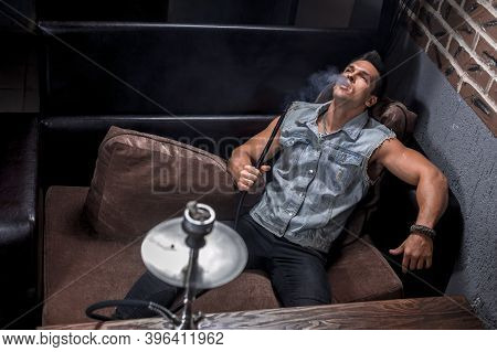 Sexy Man Enjoy Aromatic Shisha In Nightclub.