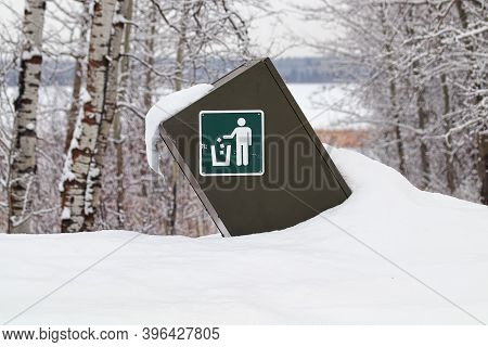 A Trash Dumpster With Instruction Sign In The Winter