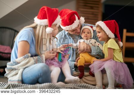 Happy parents spening Christmas time together with their kids; Family holiday concept
